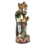 A gilt and colour painted kris stand, in the form of a crouching bearded godlike figure, provision