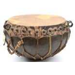 A Sudanese Dervish camel drum, of dark wood bowl form, iron studs around the top on to which is