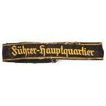 A scarce Third Reich cuff band, yellow embroidered on black “Fuhrer Hauptquartier”. FC (worn and