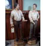 A pair of well executed painted figures of fencers, Edwardian style dress, facing each other, one