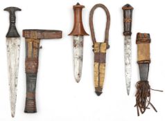 A Sudanese arm dagger, carved wooden grip of traditional form, panelled leather sheath and loop; 2