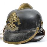 An Imperial German fireman’s leather helmet, brass front peak binding, plain crest and badge with