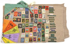 An interesting Scouts grey wool blanket, folded and embellished with approx 250 cloth insignia of