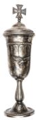 A German silver plated cup, height 13½” including lid, the body of the cup having superimposed metal
