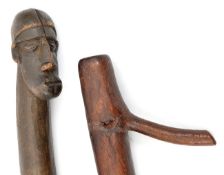 A Pacific Islands ceremonial stave, of stout dark hardwood, the top carved in the form of a man’s