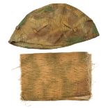 A camouflage helmet cover, with tabs for inserting additional grass, twigs etc; and a piece of