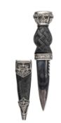 A skean dhu, blade 3½” with short fuller and scalloped back edge, strapwork bog oak grip, silver