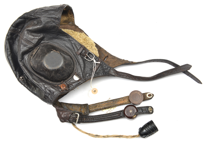 A WWII German leather flying helmet, with earphones, throat microphones, and cable with plug. GC (