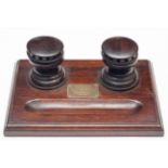 An interesting polished dark oak desk stand from the timbers of HMS Britannia, with 2 inkwells in