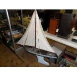 A mid 20thC wooden pond yacht. With cotton sails, rigging, dark stained decking with dark and