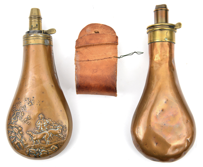 A copper powder flask, embossed on one side with a hunter and 2 dogs under a tree, spring top,