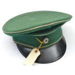A Third Reich or earlier peaked cap, apple green with white piping, black fibre peak and black and