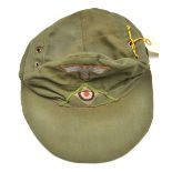 A German Afrikakorps ski cap, green piping on front, red cotton lining with maker’s name stamp and