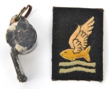 A plated whistle, marked “AM” and crown 23/230 (rust patches) and an embroidered “Goldfish Club”