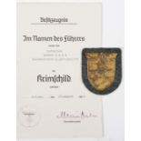 A Third Reich Krim shield, on field grey patch with paper backing (some staining to shield),