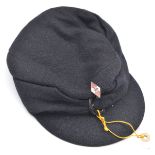 A dark blue felt soft peaked cap, with padded lining, the front with pinback enamelled Hitler