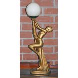 An Art Deco gilt plaster lamp formed as a female nude holding the spherical glass shade, height