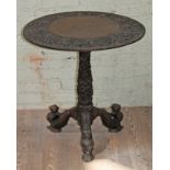 An Indian carved hardwood tripod table, diam. 68cm & height 70cm.