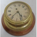 A ships brass clock mounted on wood, diam. 24cm.