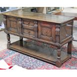 An aged oak sideboard with marquetry panelled doors depicting birds and flowers, lower pot board