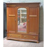 An Edwardian crossbanded mahogany triple wardrobe with central mirror, the gilt brass handles