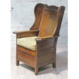 A George III oak lambing or bible chair with wing back and box seat, width 75cm, depth 72cm & height