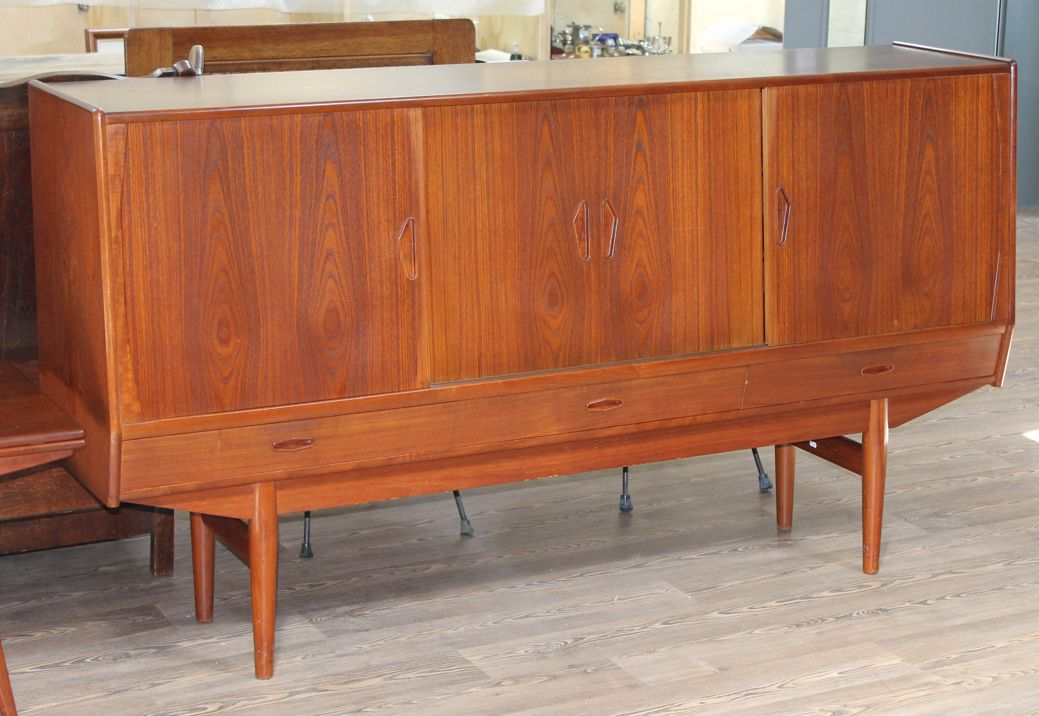 A Danish teak 1960s sideboard with slide doors revealing fitted central cupboard and shelves