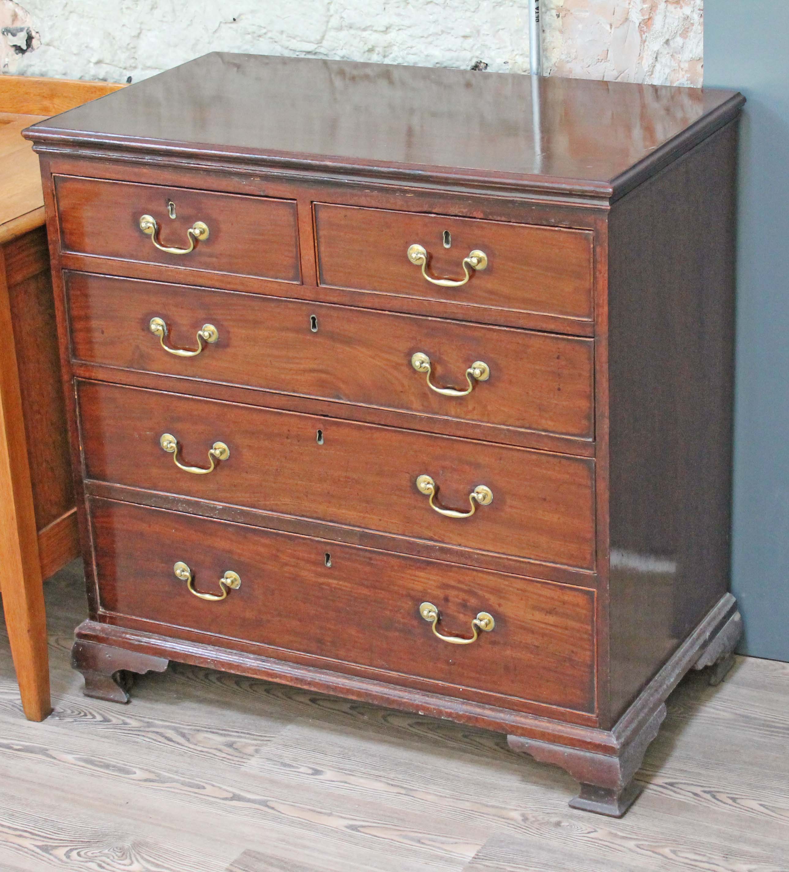 A Georgian mahogany chest of drawers having gilt brass handles and ogee bracket feet, width 90cm,