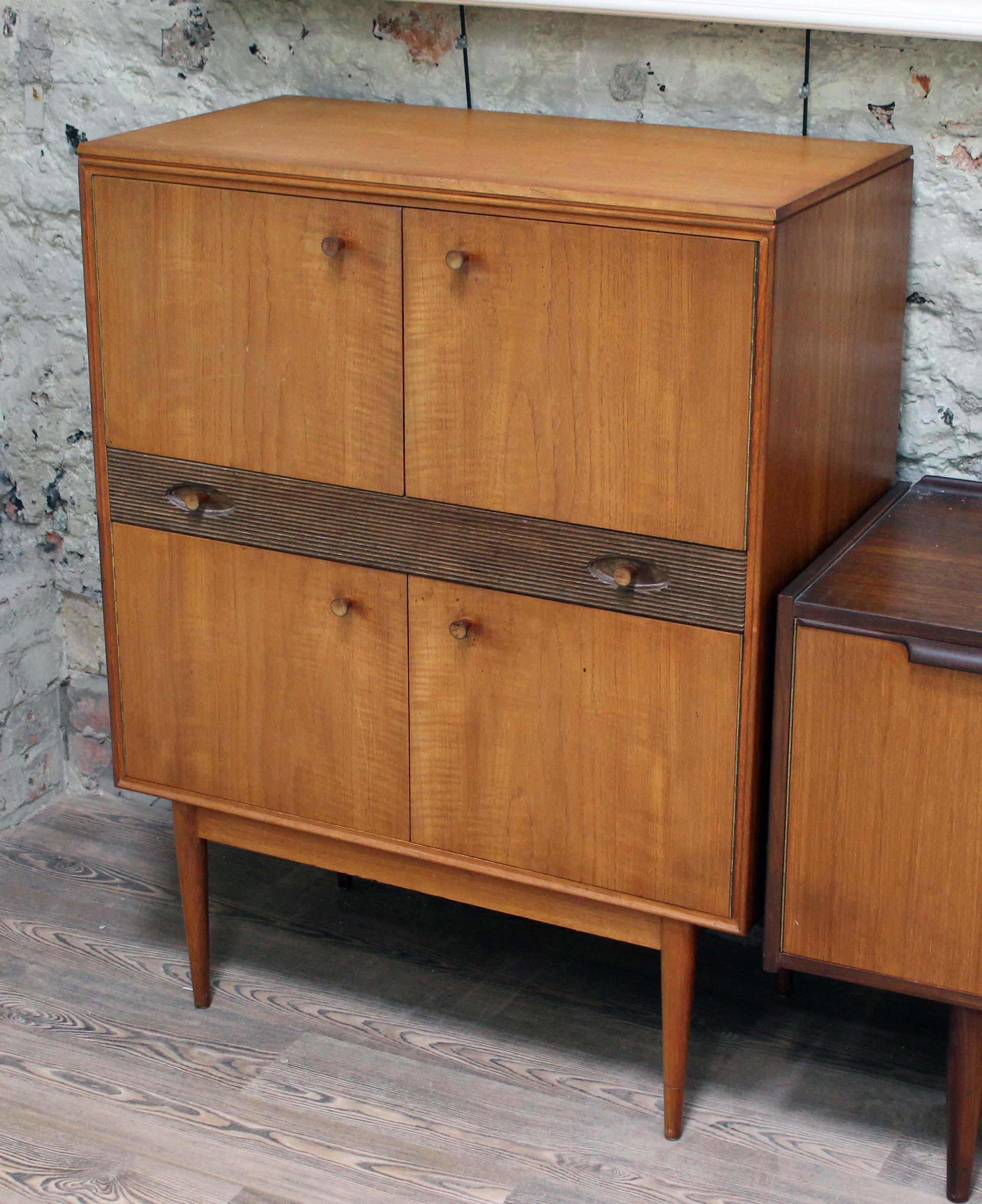 A 1960s retro teak cocktail cabinet on spindle legs, width 87.5cm, depth 46cm & height 115cm.