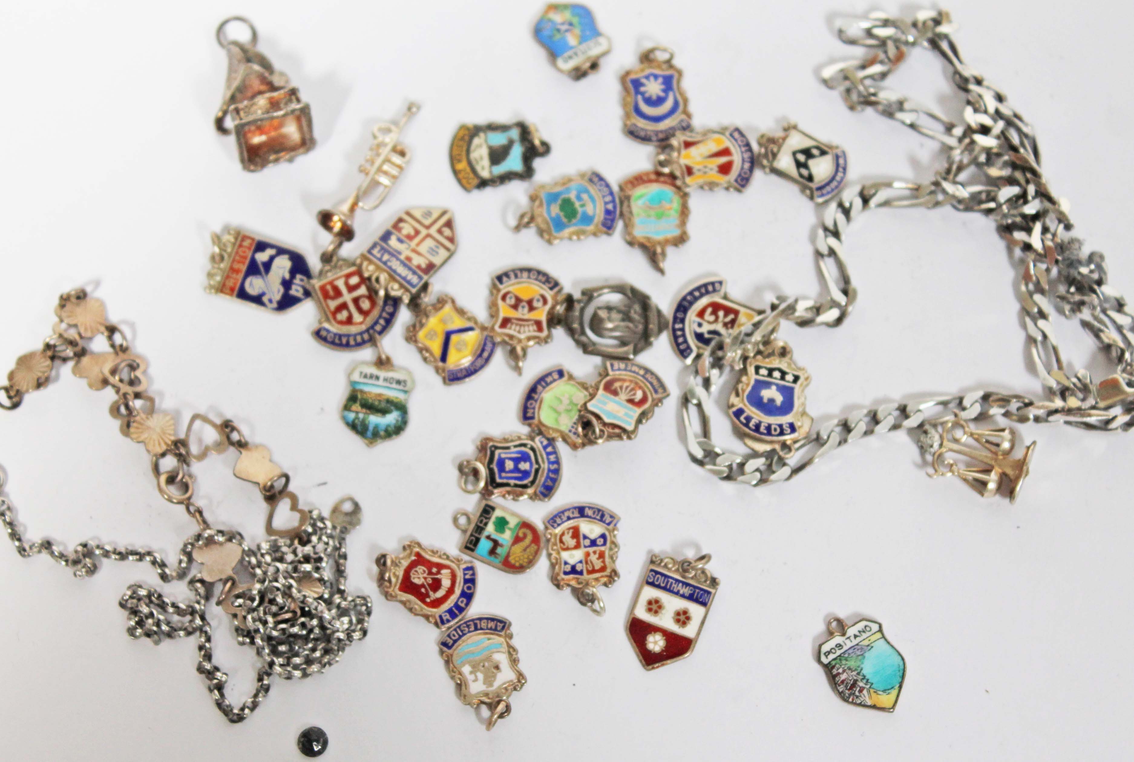 A group of enamel charms some hallmarked and others marked 'silver', together with a chain marked '