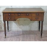 A Regency mahogany side table or desk with five drawers, turned legs with brass castors, width