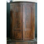 A George III inlaid mahogany bow front corner cabinet, height 112cm.