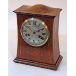 An Arts & Crafts inlaid oak mantel clock with domed top, the steel dial inscribed 'E J Knises