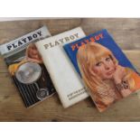 Three issues of vintage Playboy magazine.