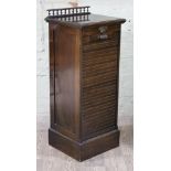 A late Victorian tambour front mahogany office cabinet with spindle rail back and pierced brass