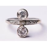 An Art Deco diamond ring, two bezel set diamonds approx. 0.25 carats each, diamond set white metal