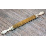 A Victorian turned and fluted bone needle case, length 11cm.