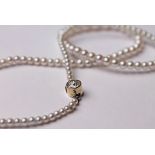 A single strand pearl necklace with yellow metal diamond set clasp, the stone approx. 0.50 carats,