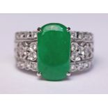 An Art Deco style white metal diamond and jade cabochon ring, the band marked '18K', gross wt. 5.7g,