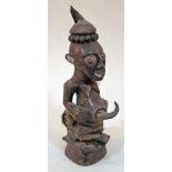 A Democratic Republic of Congo Power Figure, carved in hardwood with a horn potruding from the