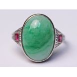 An Art Deco jade cabochon ring with diamond and ruby shoulders, white metal band marked '18ct',