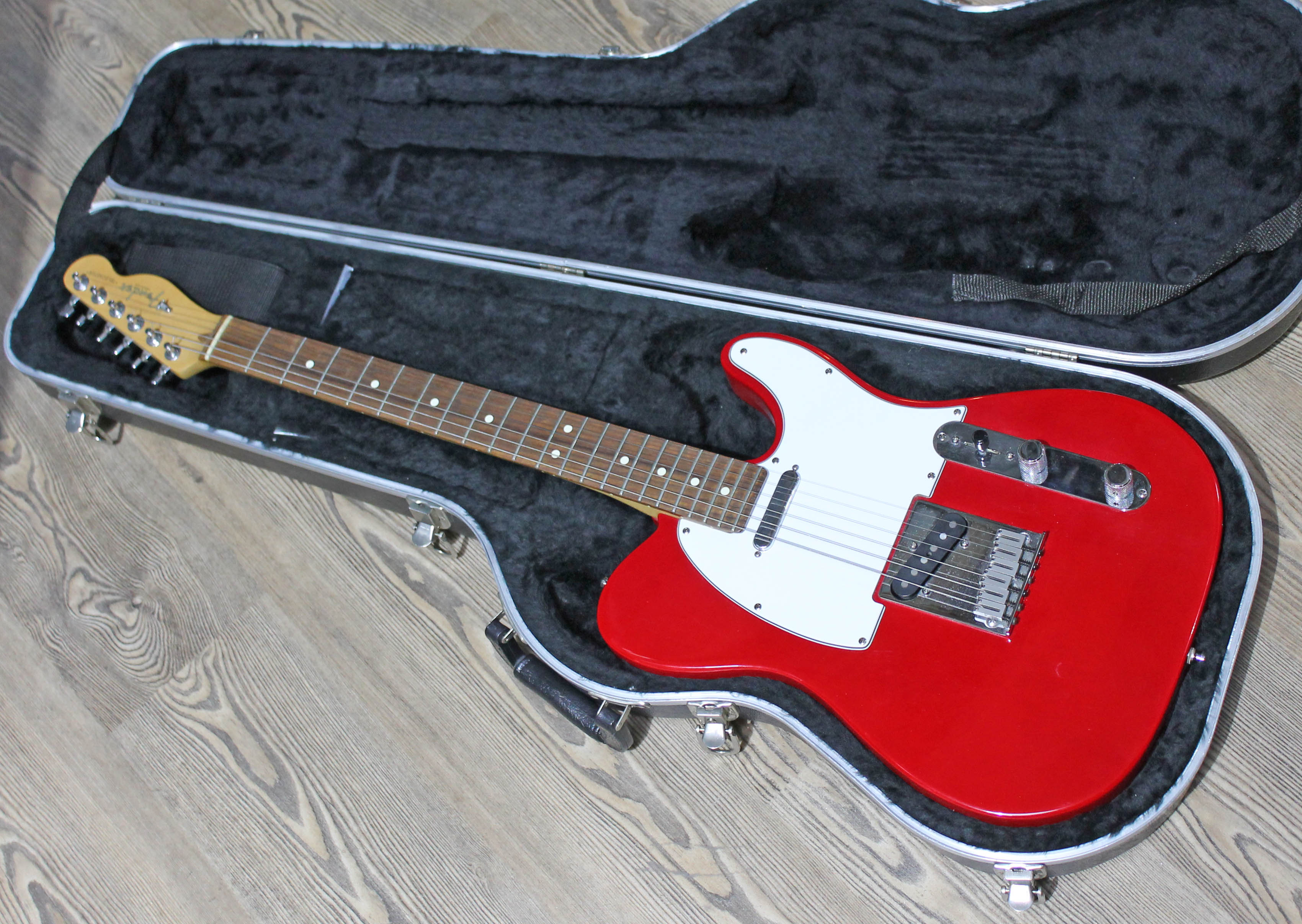 A Fender USA Telecaster in candy apple red, serial number N5102638, with hard case.