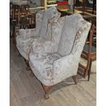 A pair of Georgian style wing back armchairs each with cream damask upholstery, shaped back,