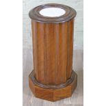 A French 19th Century walnut pot cupboard of cylindrical and fluted form with marble inset top and