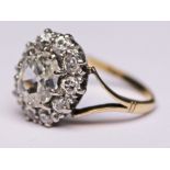 A diamond cluster ring, the oval cut central stone approx. 0.70 carats, the band marked '18ct',