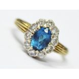 A hallmarked 18ct gold ring set with an aquamarine coloured stone and 10 diamonds, gross wt. 3.4g,