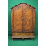 Walnut bow topped two door wardrobe the doors opening to reveal hanging rail over single long cross