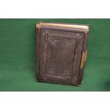 Victorian photograph album having leather embossed cover and spine opening to reveal a quantity of