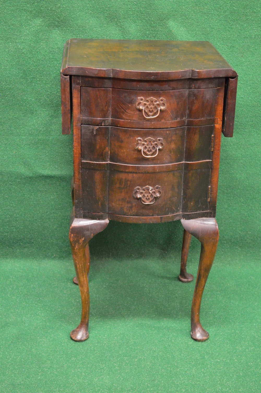 Mahogany drop flap side cabinet having two drop flaps and shaped front over single drawer and