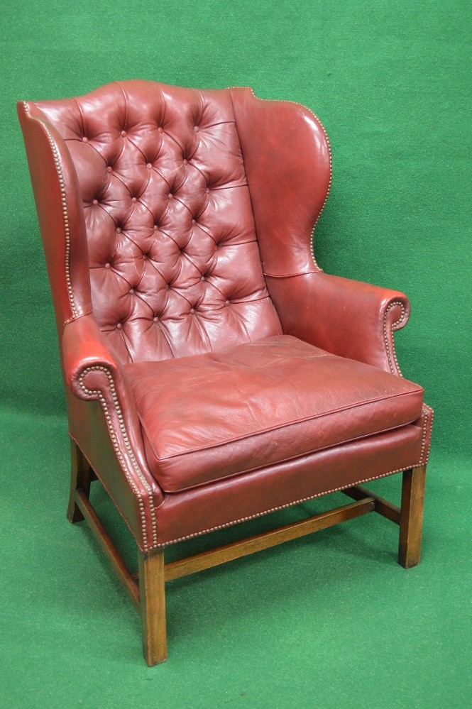 Red leather buttoned back wing armchair having removable seat cushion,